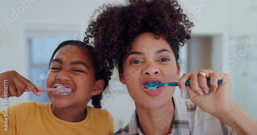 Mother, daughter and brushing teeth for dental hygiene, oral health and wellness, bathroom and support. Happy family, toothbrush and smile or laughing, clean and fresh breath or mouth, care and joy photo