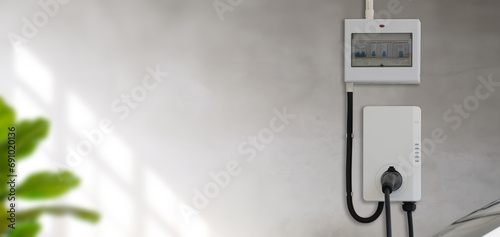 Fototapeta Naklejka Na Ścianę i Meble -  Electric car parking charging at smart house garage wall box charger station stand at family home. green energy,love nature,eco energy concept.