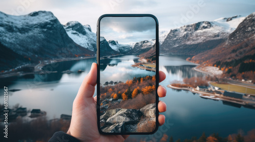 hand holding smartphone in the beautiful scenery with lake photo
