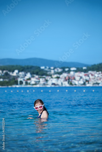 little girl plays and swims in the water in the sea 