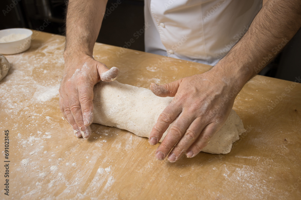 A baker prepares bread for baking