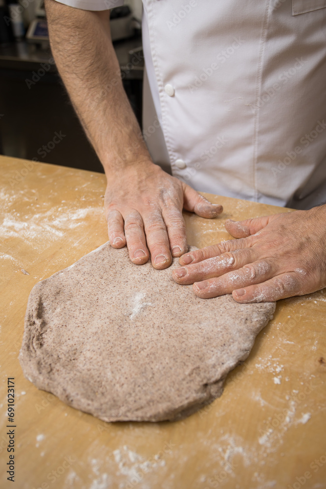 A baker prepares bread for baking