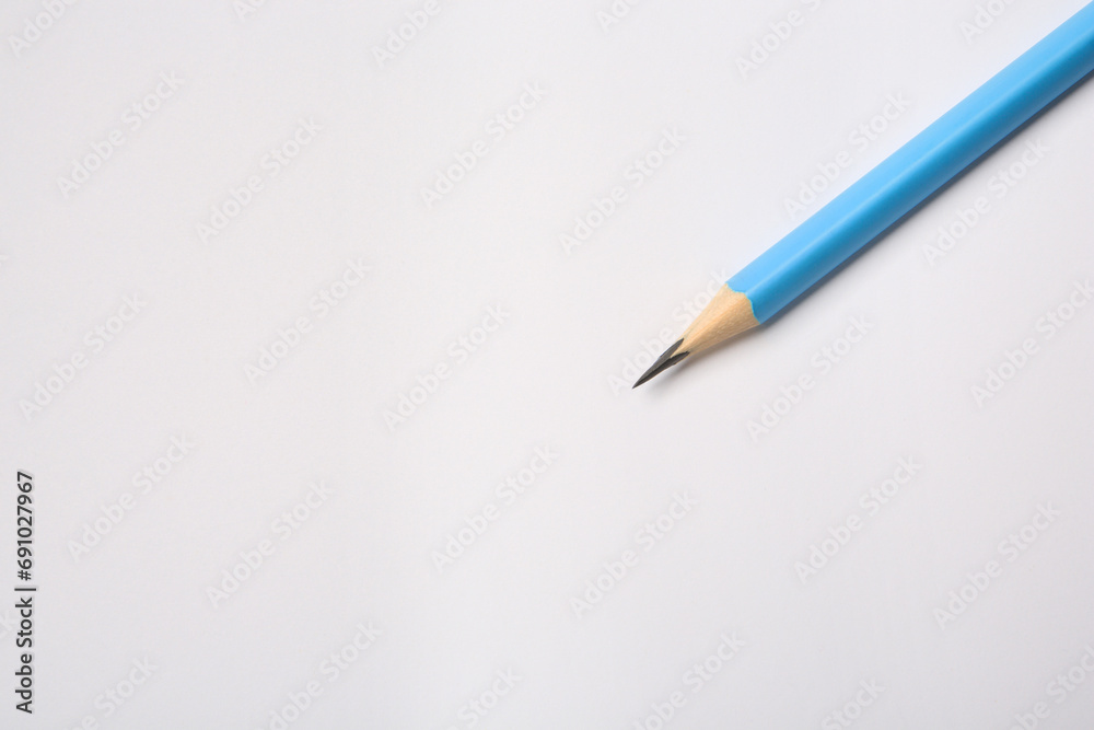 Sharp graphite pencil on white background, top view. Space for text Sharp graphite pencil on white background, top view. Space for text