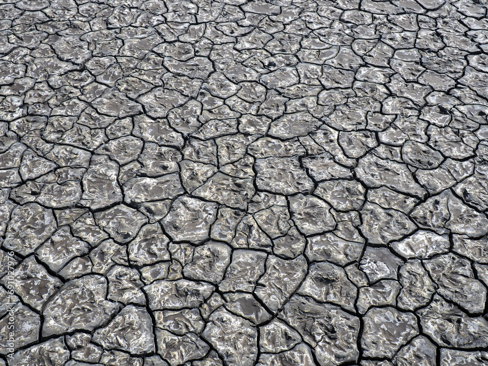 Dried out cracked mud pattern in grey color Dried out cracked mud pattern in grey color