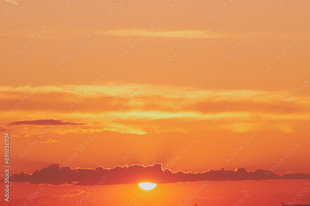 Obraz premium The yellow and orange colors of the sunrise sky were reflected in the clouds, creating a stunning dawn landscape.