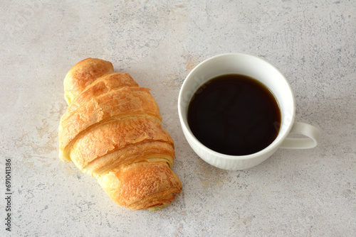 cup of strong black coffee and croissant top view 