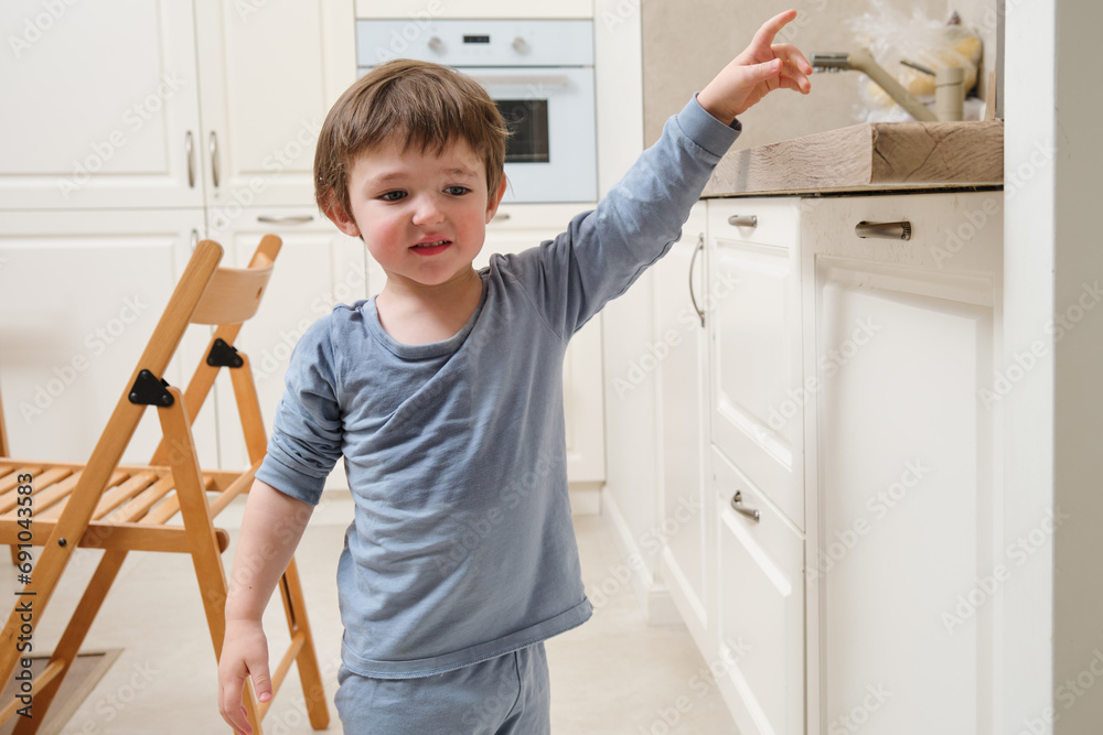 Baby boy in the kitchen, playing with a hot stove. Kid aged two (two year old) Baby boy in the kitchen, playing with a hot stove. Kid aged two (two year old)