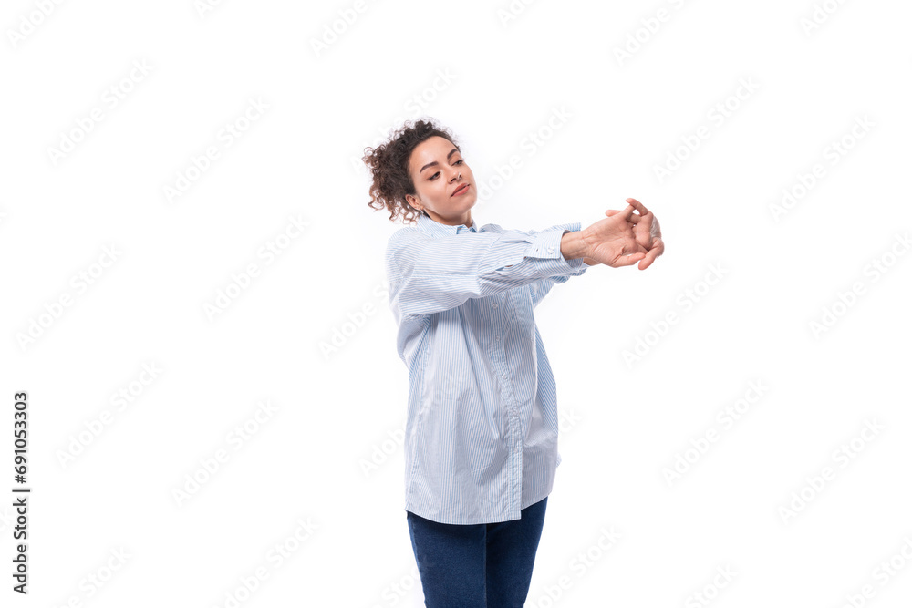 charming young brunette curly business woman in a blue shirt on a white background with copy space charming young brunette curly business woman in a blue shirt on a white background with copy space
