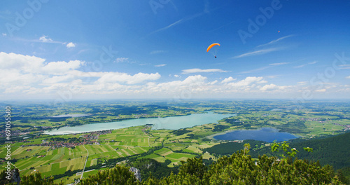 Foto Hang glider flies above lake Forggensee in Bavaria, Germany