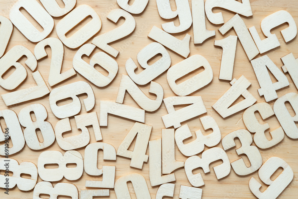 scattered wooden numbers on a wooden surface scattered wooden numbers on a wooden surface
