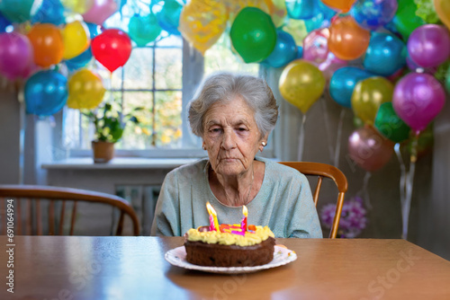 sad or depressed grandma, alone old woman on her birthday with cake photo