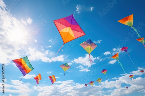 Rainbow-Colored Kites: Colorful kites flying high against a blue sky  photo