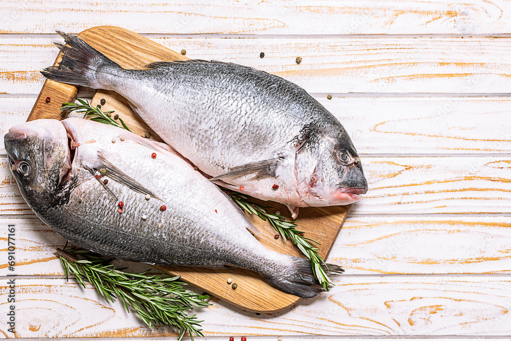 Raw dorado fish with spices and herbs in the cooking pan on white marble background top view, copy space for your design.
Raw dorado fish with spices and herbs in the cooking pan on white marble background top view, copy space for your design.
