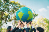 Earth day concept with big Earth globe held by group of asian business people team promoting environmental awareness to solve global warming with environmentally sustainability and ESG principle. Gyre