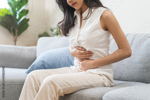 Flatulence ulcer, asian young woman, girl hands in belly, stomach pain from food poisoning, abdominal pain and digestive problem, gastritis or diarrhoea. Abdomen inflammation, menstrual period people. photo