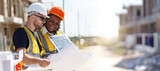 Professional - senior civil engineers inspecting or working in construction site, contractor examining a building blueprint or layout on paper.