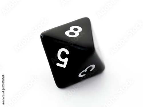 A black D8 eight sided dice isolated on white. RPG dice. Octahedron DND dice