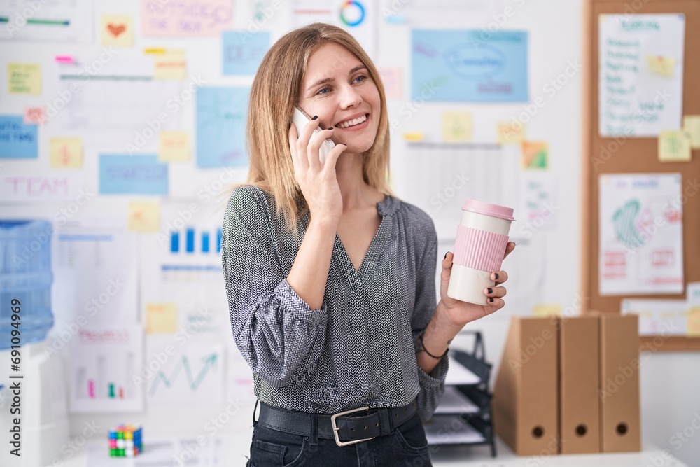 Young blonde woman business worker talking on smartphone drinking coffee at office Young blonde woman business worker talking on smartphone drinking coffee at office