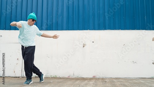 Motion shots of youthful hipster moving in lively groove at street. Caucasian break dance choreographer dancing in hip hop style. Energetic dancer perform b-boy dance. Outdoor sport 2024. Endeavor.