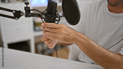 Man's hands at work, reporter speaking passionately on air at informative radio studio amidst casual indoor lifestyle