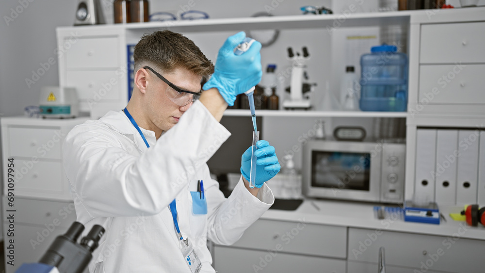Handsome, relaxed yet concentrated young caucasian male pouring liquid into test tube, deep in a riveting science experiment at his laboratory, a fascinating peek behind the scenes of medical research Handsome, relaxed yet concentrated young caucasian male pouring liquid into test tube, deep in a riveting science experiment at his laboratory, a fascinating peek behind the scenes of medical research