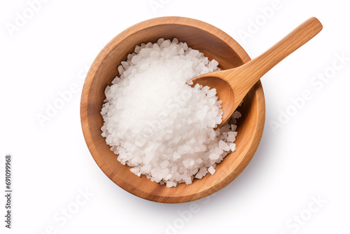 Salt in wooden bowl with spoon, flat lay from above, isolated on white.