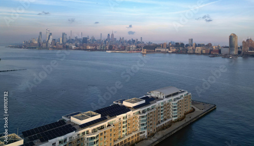 jersey city residential buildings on a pier in hudson river with midtown manhattan skyline in the background at sunset (cityscape, view, travel, homes, houses, apartments, condos, waterfront, bay)
