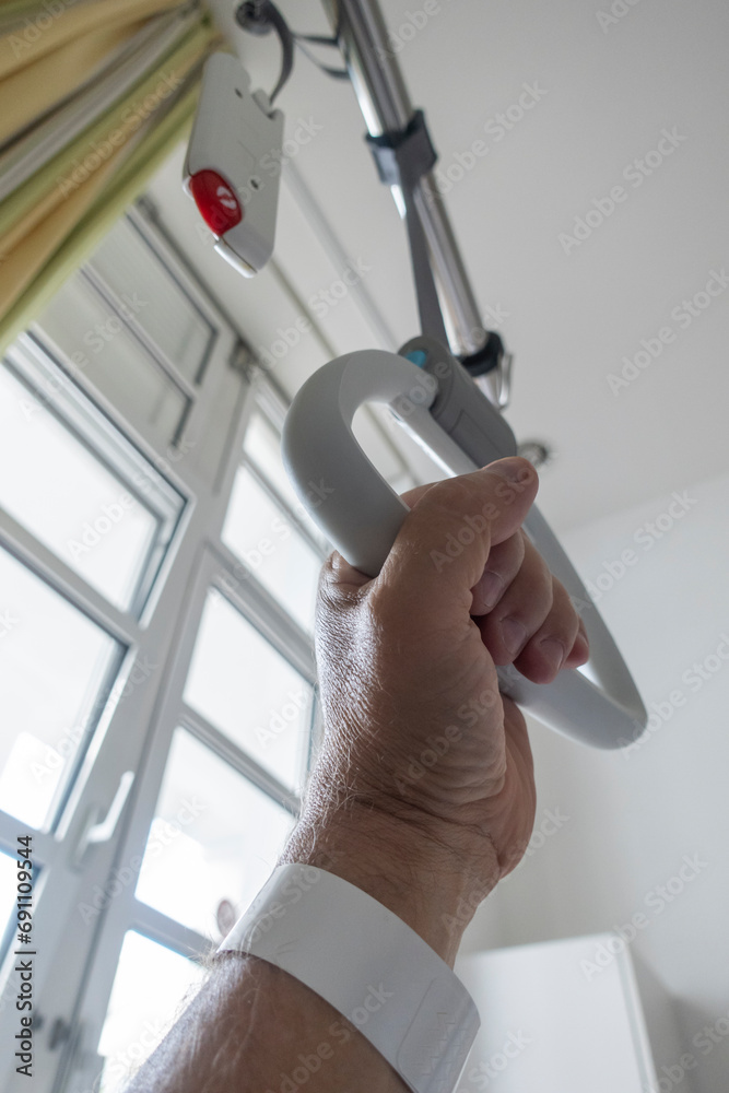 Krankenbett im Krankenhaus, Hand an einer Aufrichthilfe, Triangel, Haltegriff Krankenbett im Krankenhaus, Hand an einer Aufrichthilfe, Triangel, Haltegriff