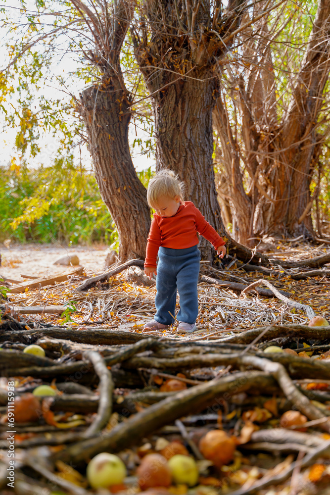 Stylish little toddler child girl in vest in autumn park