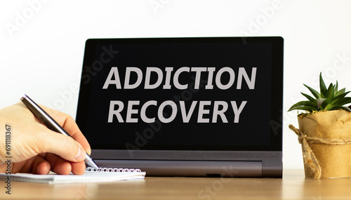 Addiction recovery symbol. Concept words Addiction recovery on beautiful black tablet. Beautiful white background. Psychologist hand. Psychology addiction recovery concept. Copy space.