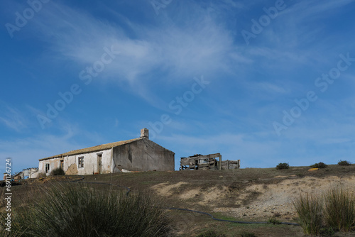 abandoned house on a hill in the middle of the countryside on a beautiful sunny blue day in portugal