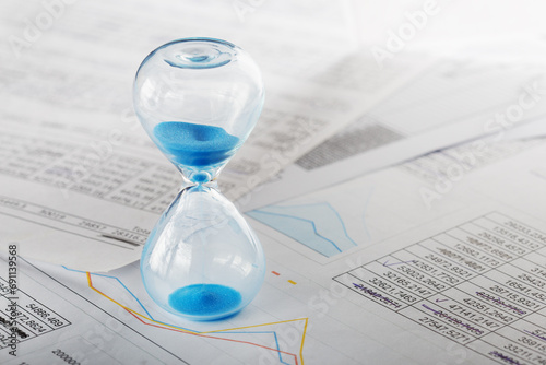 Best time for investment. Hourglass, financial charts and calculator.