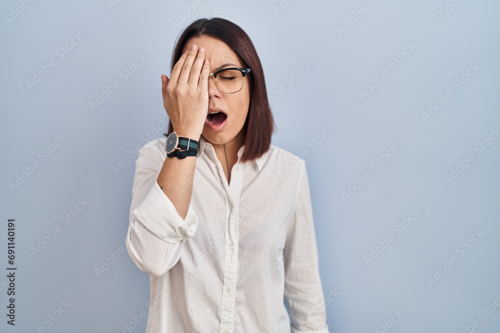 Young hispanic woman standing over white background yawning tired covering half face, eye and mouth with hand. face hurts in pain. Young hispanic woman standing over white background yawning tired covering half face, eye and mouth with hand. face hurts in pain.