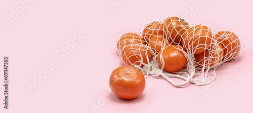 A cotton mesh bag with fresh citrus fruits. Free space for text.