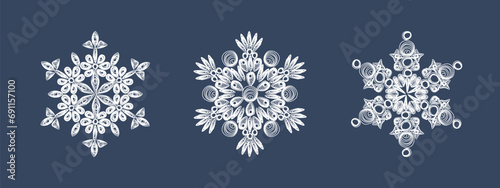 A set of stylish white quilling snowflakes on a dark blue background. Paper openwork weaving technique. Elements of quilling. New Year's symbols in the pattern. photo