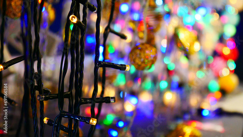 Fotografia Close-up of a black wired electric garland and many others blurred behind it bli