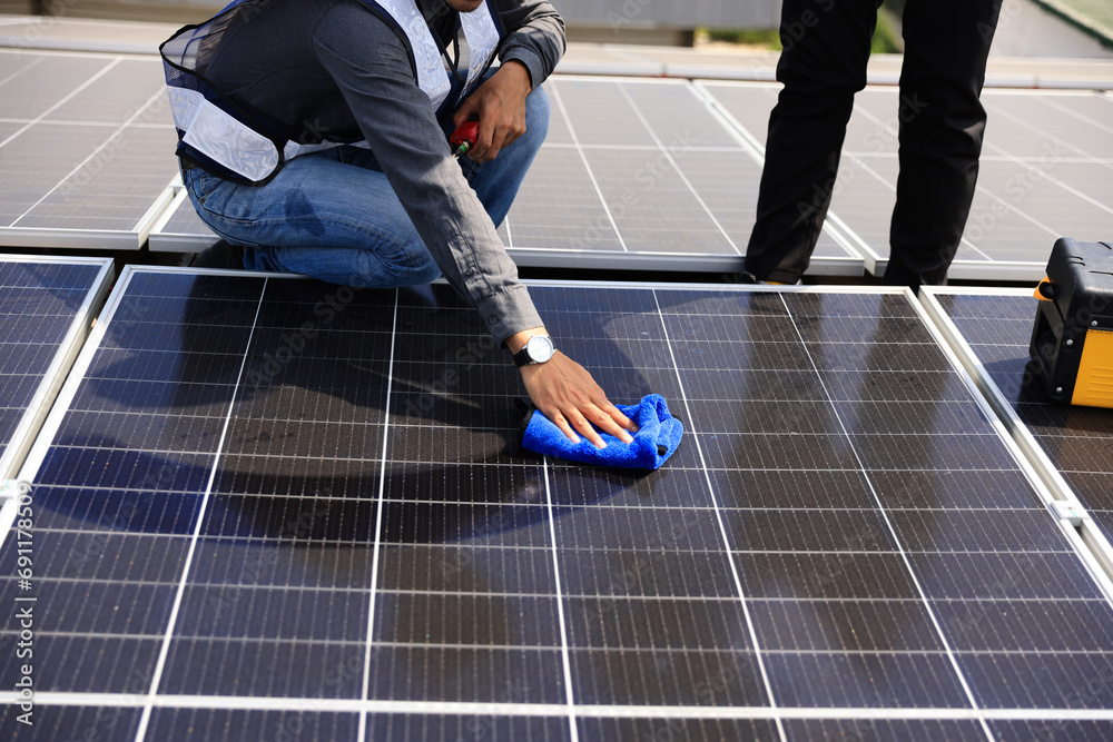 Fototapeta premium Solar technician cleaning the solar panel , Green and renewable energy concept