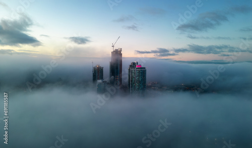 Residential Apartment home Buildings covered in fog at winter sunrise. Modern Cityscape Aerial Background © edb3_16