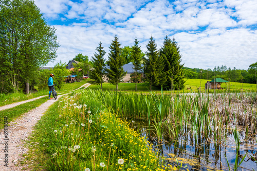 Cyclist on gravel road In Suwalski Landscape Park during spring season, Podlasie, Poland photo