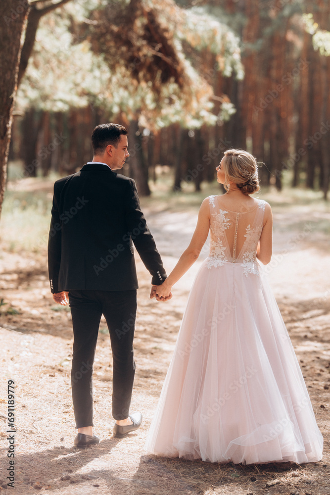happy bride and groom walking in the summer forest