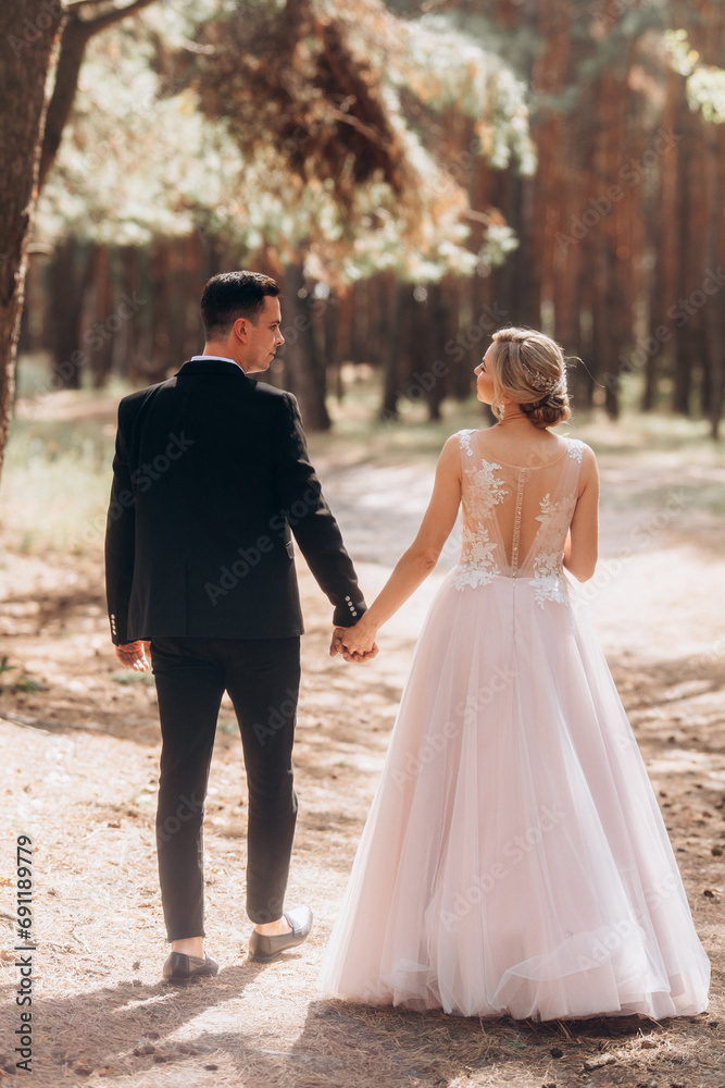 happy bride and groom walking in the summer forest happy bride and groom walking in the summer forest