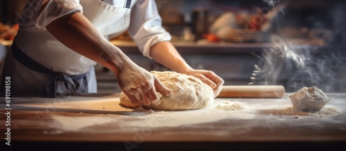 Close up view of baker cutting bread dough with steel scraper in bakery. Copy space image. Place for adding text