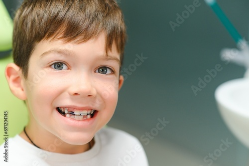 The boy inserts an orthodontic plate in his mouth