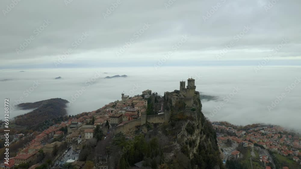 Drone aerial view of San Marino castle on a cloudy day above the mountain Drone aerial view of San Marino castle on a cloudy day above the mountain