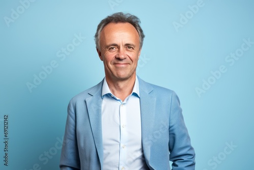 Portrait of a happy senior man looking at camera on blue background