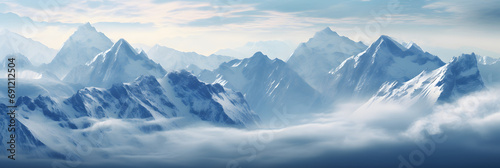 a panoramic view of snowy mountains with snow covered peaks covered with fog and snow in winters © DailyLifeImages