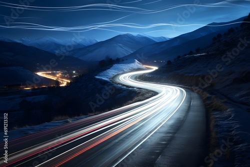 a highway road with cars moving fast with motion blur between snowy mountains © DailyLifeImages