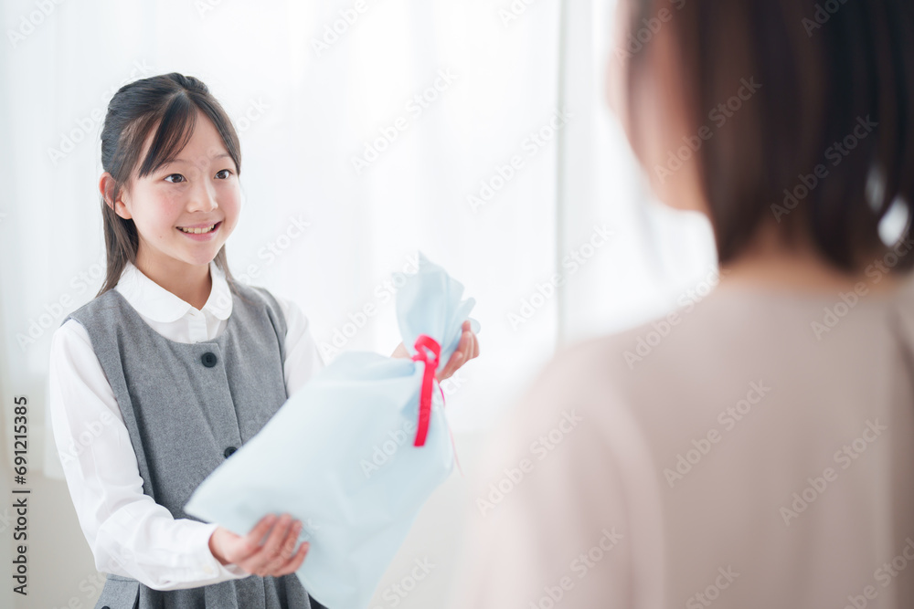 お母さんにプレゼントを渡す女の子 お母さんにプレゼントを渡す女の子