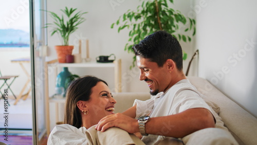 Funny spouses joking hotel closeup. Gentle man caresses wife relaxing soft couch