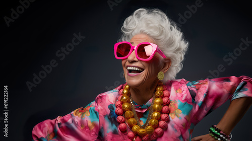 Crazy cool granny, elderly woman with headphones, sunglasses and gray hair, expressive mature and happy smiling grandmother in colorful close-up portrait   Generative AI © DigitalDreamscape